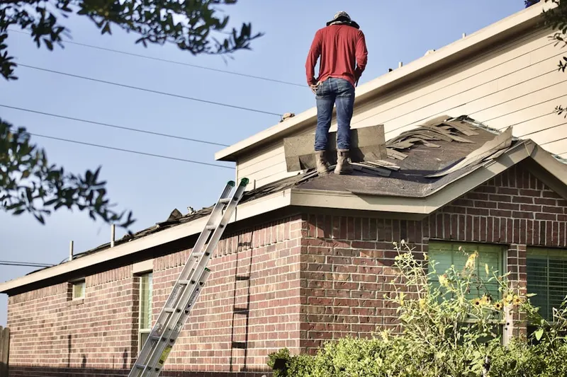 Professional roofer working on a residential roof in Muttontown
